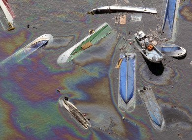 Vessels float on oil spilled water in Fudai in northern Japan.