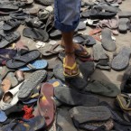 A young Bahraini anti-government protester slips into a pair of plastic shoes from a collection at Pearl roundabout in Manama, Bahrain, lost by people during Sunday's fierce clashes. (AP Photo/Hasan Jamali)