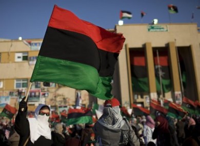 A Libyan woman holds a pre-Gaddafi flag during an anti-Gaddafi protest in Benghazi in April 2011.