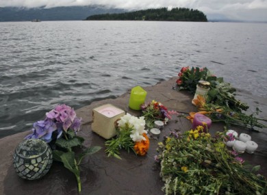 Flowers and candles left in memory of the victims of the shooting lie on the shore opposite Utoya.