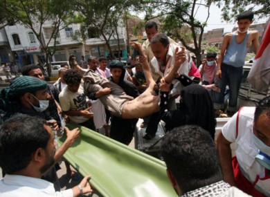 Anti-government protestors carry a wounded protestor from the site of clashes with security forces, in Taiz, Yemen, yesterday