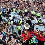 The jeeps make their way through the packed streets.