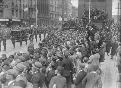 Crowds gather at Nelson's Pillar on O'Connell Street as new President Douglas Hyde's cavalcade passes by on 25 June 1938.