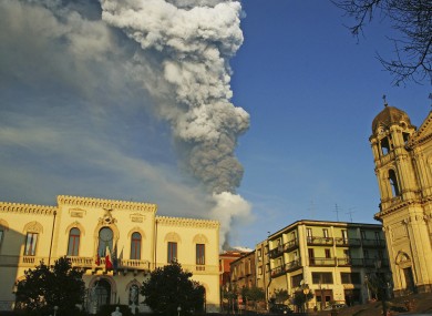 Smoke and ash billow from Mount Etna framed by the Sicilian town of Zafferana earlier today.