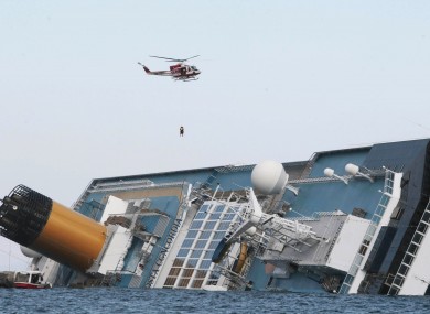 An Italian firefighter helicopter perfroms a rescue operation as it flies over the luxury cruise ship Costa Concordia which ran aground the tiny Tuscan island of Giglio, Italy
