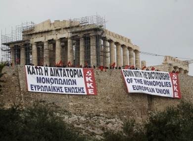 Greek communist parties hold banners at Athen's Acropolis hill.