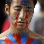 An exile Tibetan, with the Tibetan flag painted on his body, participates in a march in New Delhi, India. (AP Photo/Tsering Topgyal)