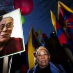 A woman carries a photo of the Dalai Lama opposite the Chinese Embassy during a protest against China's rule in Tibet in Madrid, Spain. (AP Photo/Andres Kudacki)