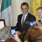 Obama touches a certificate of Irish Heritage that was presented to him by Kenny during a St. Patrick's Day reception in the East Room (AP Photo/Susan Walsh)