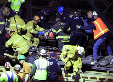 Emergency services remove an injured man from the scene of a crane collapse in Manhattan.