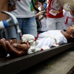 Volunteers drive nails through the palms of a unidentified Catholic devotee in a reenactment of the crucifixion of Jesus Christ at San Pedro Cutud, Philippines (AP Photo/Bullit Marquez)
