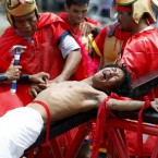 Volunteers dressed as Roman Centurions, drive nails through the palms of an unidentified Catholic devotee in a reenactment of the crucifixion at San Pedro Cutud, Philippines (AP Photo/Bullit Marquez)