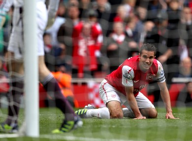 Arsenal's Robin van Persie kneels dejected after his shot on goal hits the side netting.