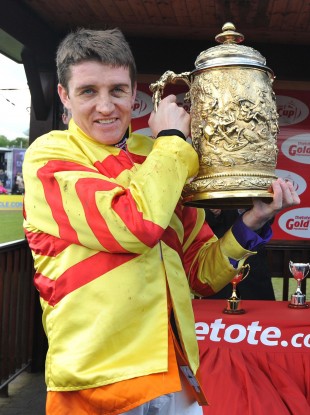 Jockey Barry Geraghty holds the trophy after China Rock won the tote.com Punchestown Gold Cup.