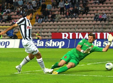 Juventus's Mirko Vucinic scores past Cagliari goalkeeper Michael Agazzi.