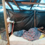 A woman lies in bed with her daughter inside a shack in a area occupied by Members of the Brazil's Landless Movement (MST) in Embu das Artes, outskirt of Sao Paulo, Brazil, Monday, May 7, 2012. (AP Photo/Andre Penner)