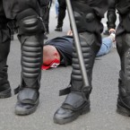 A handcuffed Polish fan sits on the streets prior to the Euro 2012 soccer championship Group A match between Poland and Russia in Warsaw, Poland, Tuesday, June 12, 2012. (AP Photo/Gero Breloer)