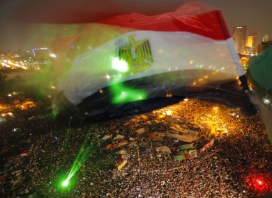 An Egyptian waves a national flag over Tahrir Square as people celebrate the election of Mohammed Morsi.
