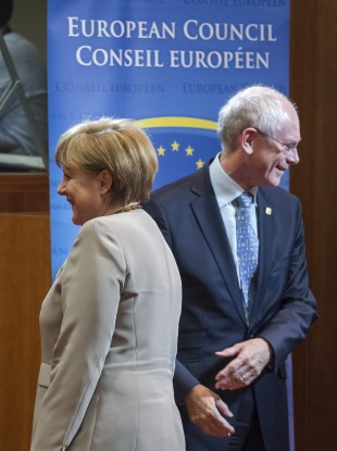 German Chancellor Angela Merkel, left, walks by European Council President Herman Van Rompuy during a round table at the EU Summit in Brussels