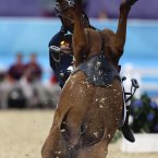 Hwang Woojin, of South Korea, and his horse Shearwater Oscar, fall down after the horse bucked after the starting bell sounded to start their run in the equestrian show jumping stage of the men's modern pentathlon at the 2012 Summer Olympics. (AP Photo/David Goldman)