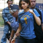 Nadezhda Tolokonnikova, a member of feminist punk group Pussy Riot greets her supporters as she is escorted to a court room in Moscow. On Friday, the three women were found guilty of hooliganism motivated by religious hatred for staging an anti-Putin protest at a Moscow cathedral. (AP Photo/Alexander Zemlianichenko)
