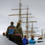 Tall ships and their visitors reflected in a puddle. (Julien Behal/PA Wire)