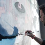 Artist Colm MacAthlaoich puts the finishing touches to his artwork in the festival's first Heineken beer garden near the main stage. (Laura Hutton/Photocall Ireland)