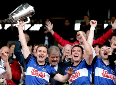 Sarsfields' Joe Barry lifts the trophy alongside Cian McCarthy and Ray Ryan.