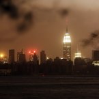 The New York skyline remains dark on Monday, as seen from the Williamsburg neighborhood in the Brooklyn borough of New York. In an attempt to lessen damage from saltwater to the subway system and the electrical network beneath the city's financial district, New York City's main utility cut power to about 6,500 customers in lower Manhattan. But a far wider swath of the city was hit with blackouts caused by flooding and transformer explosions. (AP Photo/Frank Franklin II)