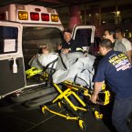 Medical workers assist a patient into an ambulance during an evacuation of New York University Tisch Hospital, after its backup generator failed when the power was knocked out by a superstorm on Monday, in New York. Dozens of ambulances lined up outside NYU Tisch Hospital on Monday night as doctors and nurses began the slow process of taking people out. (AP Photo/John Minchillo)
