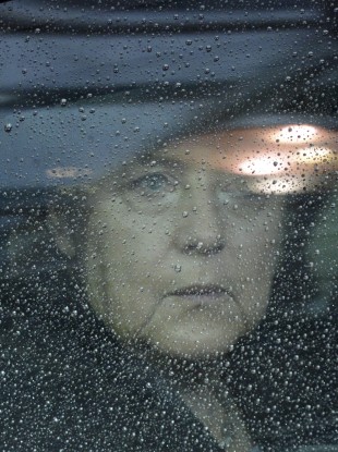 German Chancellor Angela Merkel looks out from behind raindrops on her car window as she arrives for an EU summit in Brussels