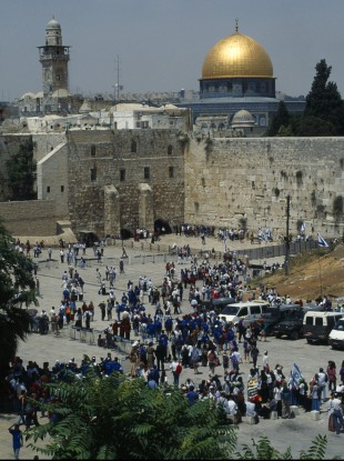 Israel, Jerusalem, Gold dome of the Aska Mosque and western or Wailing Wall with crowds of worshippers.