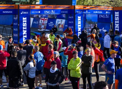A crowd of runners stands near the barricaded Central Park finish line for the now-canceled New York Marathon.