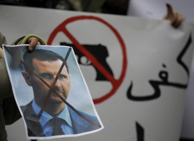 A Syrian immigrant holds a crossed out depiction of Syrian President Bashar al-Assad during a rally against his regime in late 2011.