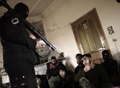 Syrian rebels listen to their trainer on how to use a rocket propelled grenade near Idlib, Syria