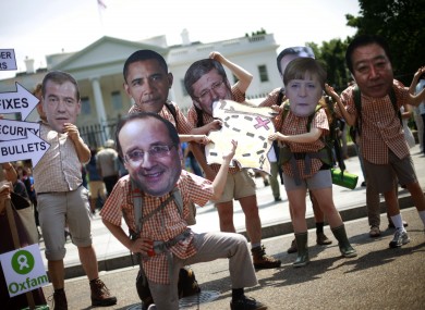 Oxfam activist wearing masks depicting G8 world leaders participate in a demonstration outside the White House in Washington last year