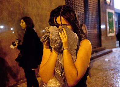 A woman covers from tear gas fired by police near the Cinelandia square in Rio de Janeiro