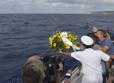 Fishing boat captain Calosero Spalma throws a wreath into the sea to pay tribute to the victims of Thursday's migrant shipwreck