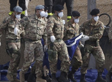 Italian soldiers carry body bags at the Lampedusa island, Italy